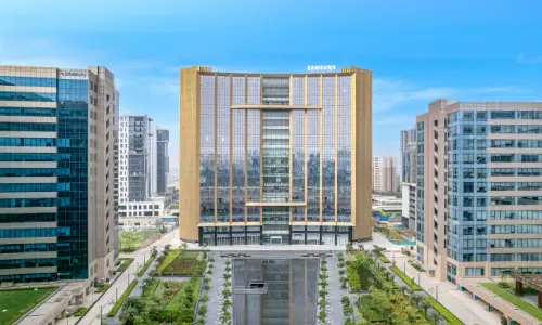 Candor TechSpace, Sector 135, Noida, featuring a modern glass building surrounded by office towers and green landscaping.