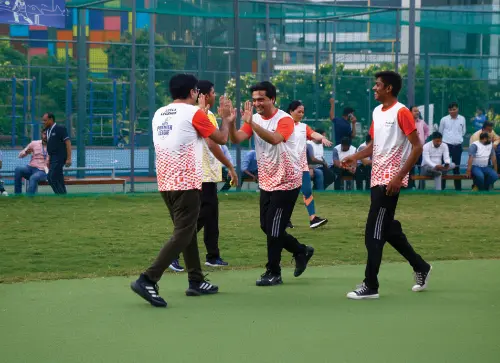 A group of people in matching shirts celebrating and high-fiving during a sports event