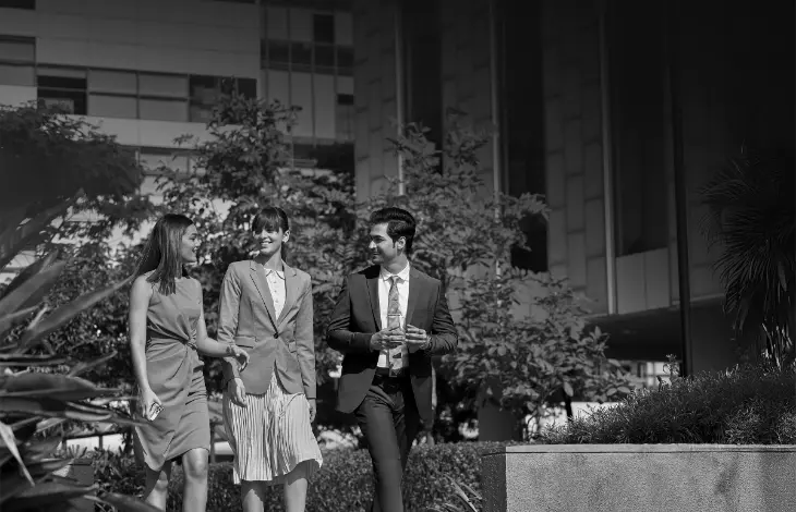 Business professionals walking together at Candor TechSpace, Newtown, Kolkata, surrounded by greenery in a modern office environment.