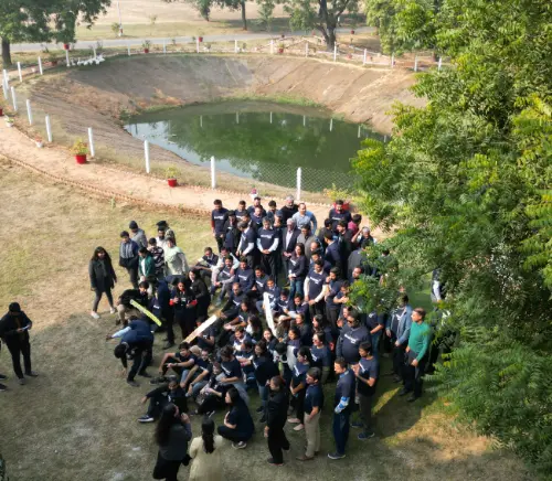 A large group of Brookfield Properties employees posing for a team photo outdoors, with a pond in the background