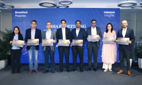 A group of professionals holding event signs at a Brookfield Properties and Nasscom Insights event, standing in front of a blue backdrop.